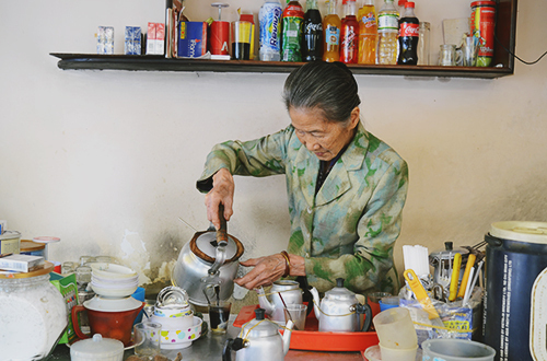 Bà Năm vẫn ngày ngày đứng chế từng mẻ cà phê cho thực khách. Ảnh: Phong Vinh