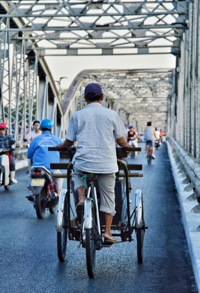 Cảnh người đi bộ, đạp xe, bác xích lô, những thồ hàng qua về hai bờ Bắc Nam giao thương chợ Đông Ba... khắc họa nét bình yên, dân dã một góc Huế.