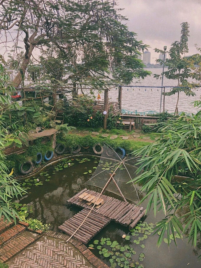 Ami GardenToạ lạc trên đường Vệ Hồ, Ami Garden được nhiều bạn trẻ gọi là khu vườn bí mật bởi không gian quán được bao phủ bởi rất nhiều cây xanh. Quán chia thành nhiều khu nhỏ, với những tràng cỏ, hồ cá, ao súng cùng nhiều loại hoa như hoa phượng đỏ, hoa giấy... Tất cả bàn ghế, đồ trang trí đều làm từ gỗ, mây nên quán mang lại cảm giác gần gũi với thiên nhiên. Ngoài ra, quán còn bố trí những chiếc chòi đối diện hồ để ngắm cảnh, thức uống có giá từ khoảng 35.000 - 60.000 đồng. Ảnh: Caibungdoi