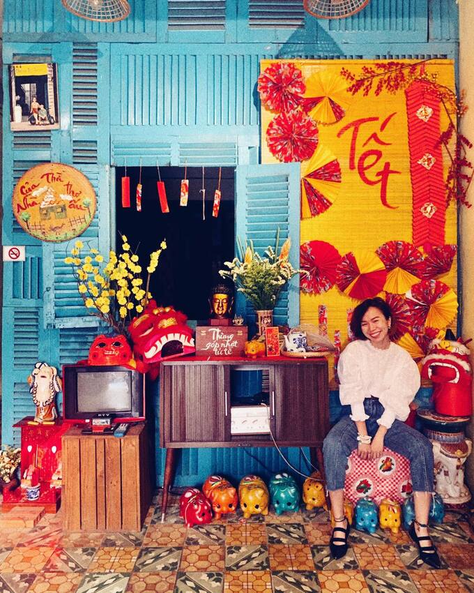 Tiệm cà phê Nhà Mình nằm trong một con hẻm tại đường Cách Mạng Tháng 8 (quận 3). Tiệm mang phong cách retro nên những dịp Tết, không gian thêm phần hoài cổ nhờ những vật dụng trang trí đậm chất cổ truyền.Tiệm có riêng một góc trang trí phục vụ khách check-in. Không gian gồm 2 gian phòng có thể chứa được 40-50 khách. Menu đồ uống dao động trong khoảng 30.000 - 40.000 đồng. Khách đến đây có chỗ gửi xe miễn phí. Ảnh: Đồng Lê Quỳnh Hương