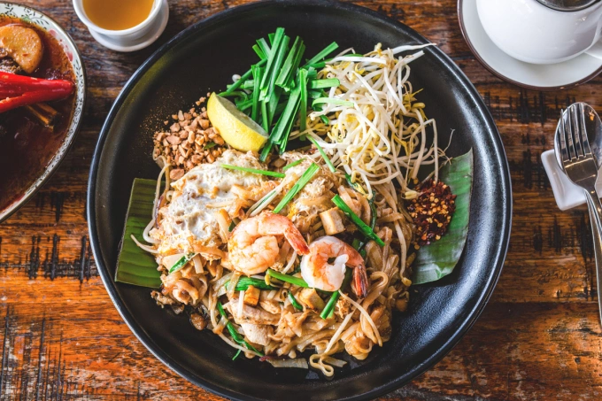 Pad Thai là một trong những món ăn chính của người dân. Đây là một món mì gạo chiên/xào truyền thống, với thành phần gồm có mì gạo xào với trứng và đậu phụ, cùng ớt đỏ, bột me, nước mắm và đường thốt nốt. Đĩa mì được trộn cùng lạc rang giã nhỏ, tôm, tỏi hoặc hẹ tây. Ảnh: Asian inspirations
