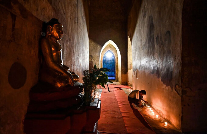 Một tín đồ Phật giáo thắp nến cúng dường tại ngôi chùa cổ Sulamani ở Bagan. Ảnh: AFP