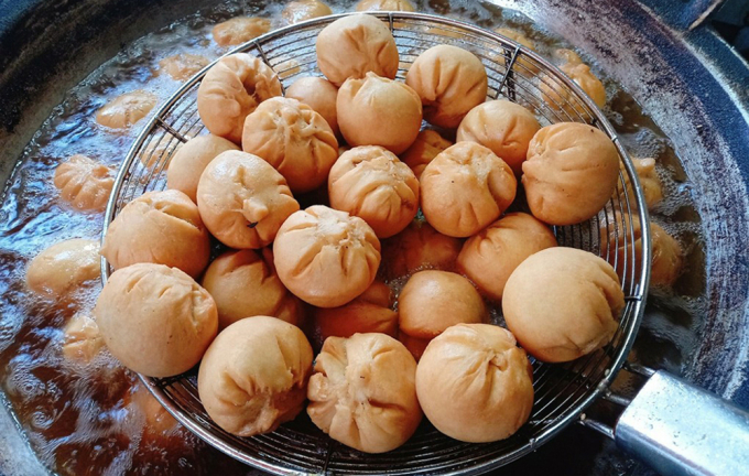 Sẽ thật thiếu sót nếu bỏ qua bánh bao, món ăn vặt được mọi người yêu thích vào mỗi tối hoặc sáng sớm mùa đông. Bánh có vỏ làm từ bột mì trộn đều cùng chút đường, muối. Nhân bánh chay hoặc gồm thịt xay nhuyễn, mộc nhĩ, trứng, nấm hương. Bánh bao có hai loại là hấp và chiên. Món chiên thường ăn kèm tương ớt hoặc nước chấm pha ngọt. Ảnh: Khánh Thiện