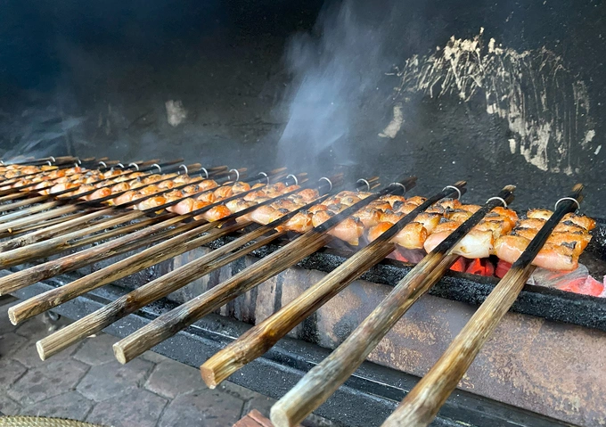 Gắp chả tôm nướng trên than hoa.