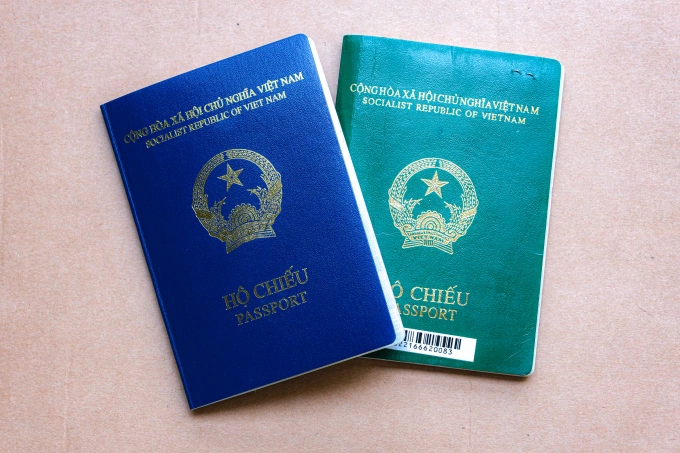 Hộ chiếu Việt Nam mẫu mới (bên trái, bìa xanh tím than) và mẫu cũ (bìa xanh lá). Ảnh: Nguyên Minh.