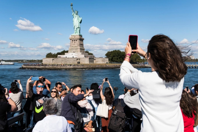 Du khách đổ xô đến chụp ảnh tượng Nữ thần Tự Do ở New York, Mỹ. Ảnh: TTG Asia