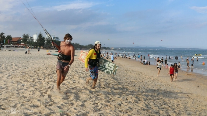 Bãi biển Mũi Né thu hút nhiếu du khách trong dịp hè, trong ảnh là hai vị khách quốc tế chơi lướt ván diều, tháng 7/2025. Ảnh: Việt Quốc