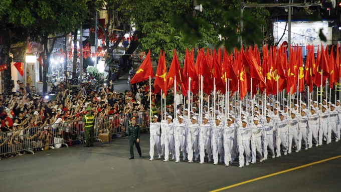 Người dân, du khách đứng kín hai bên đường Nguyễn Thái Học - Cửa Nam xem đoàn diễu binh đi qua trong buổi hợp luyện tối 21/8. Ảnh: Võ Hải