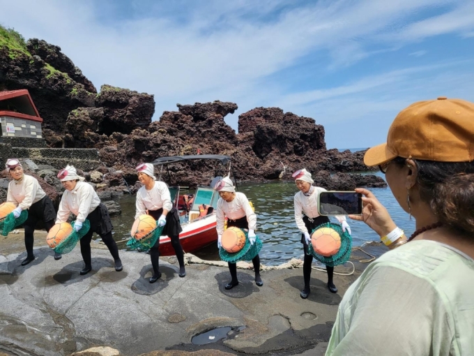 Du khách tìm hiểu về công việc của các hải nữ ở Jeju. Ảnh: hankyung