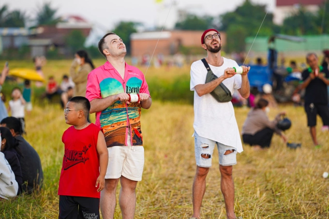 Hai du khách quốc tế thích thú trải nghiệm thả diều tại Khánh Hòa dịp hè. Ảnh: Bùi Toàn