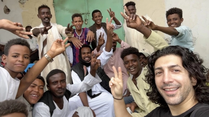 Micheael Zervos chụp ảnh cùng những người trẻ ở Port Sudan. Ảnh: Guinness World Records