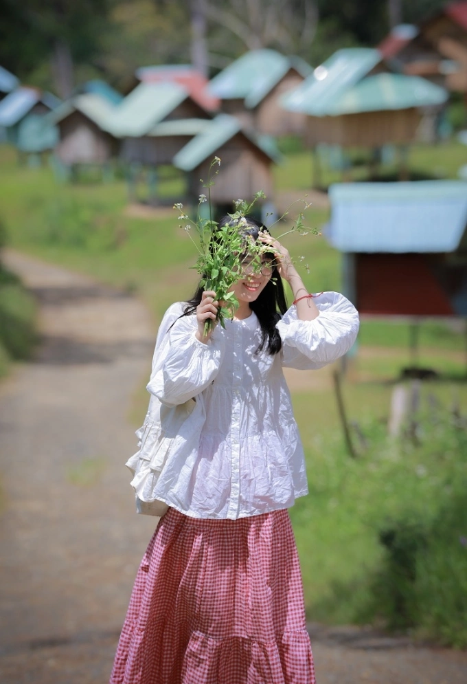 Thúy, du khách ở Hà Nội chụp kiểu ảnh chân dung với phông nền kho lúa ở Măng Đen. Ảnh: Hoàng Tour Măng Đen