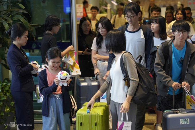 Một hành khách nhí thích thú được nhận quà lưu niệm tại sảnh đón Nhà ga quốc tế Đà Nẵng. Ảnh: Nguyễn Đông