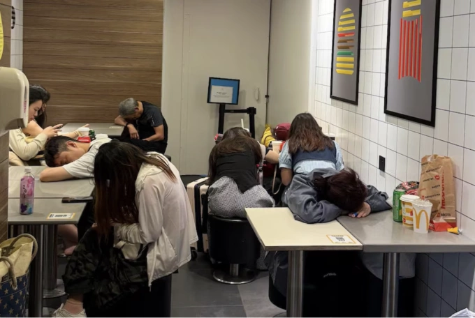Du khách theo phong cách đặc nhiệm ngủ qua đêm tại cửa hàng McDonald’s để tiết kiệm chi phí lưu trú. Ảnh: ABC News