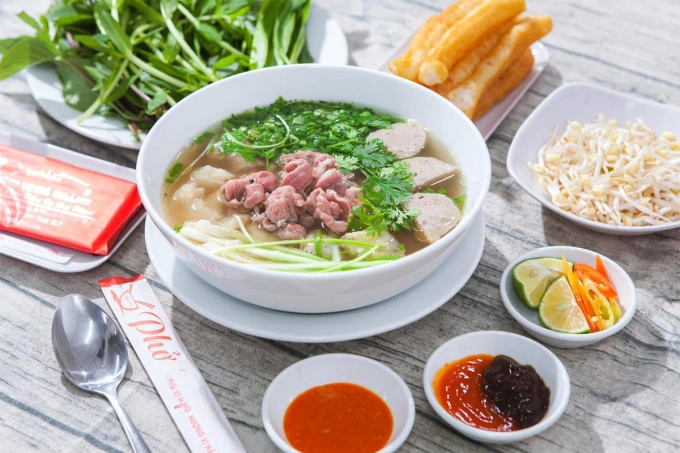 Phở Sài Gòn với bò viên, rau thơm, giá, sốt chua ngọt. Ảnh: Phở Vụ