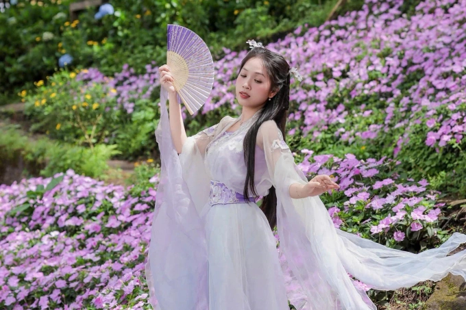 Chủ quán mặc cổ phục, trêu ghẹo khách bằng giọng phim TVB Chủ quán Kim Hương mặc trang phục cổ trang trong khuôn viên quán cà phê Happy Hill. Ảnh: NVCC