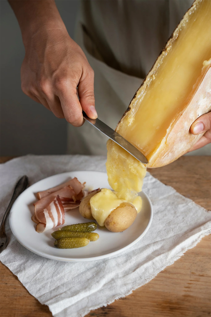 Raclette - món phomat 'cạo' nóng chảy mùa Giáng sinh Gạt phomai lên các đồ ăn đã chuẩn bị sẵn. Ảnh: epiceriecorner