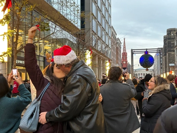 Giải mã phong tục hôn dưới cây tầm gửi đêm Giáng sinh Một cặp đôi trung niên trao nụ hôn dưới quả cầu tầm gửi ở Washington, ngày 13/12. Ảnh: Washington Post