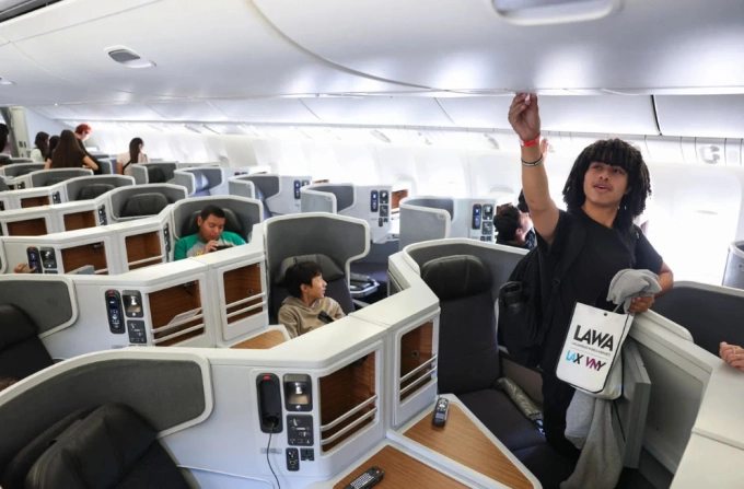 Một hành khách đang chỉnh lỗ thông gió trên khoang máy bay. Ảnh: AFP