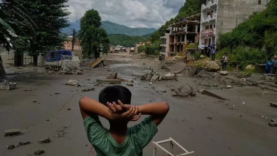 Một cậu bé đứng nhìn nhà cửa bị tàn phá do lũ quét dọc theo sông Trishuli ở huyện Nuwakot, Nepal vào ngày 28/6. Ảnh: AP